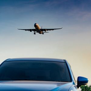 airplane flying over car